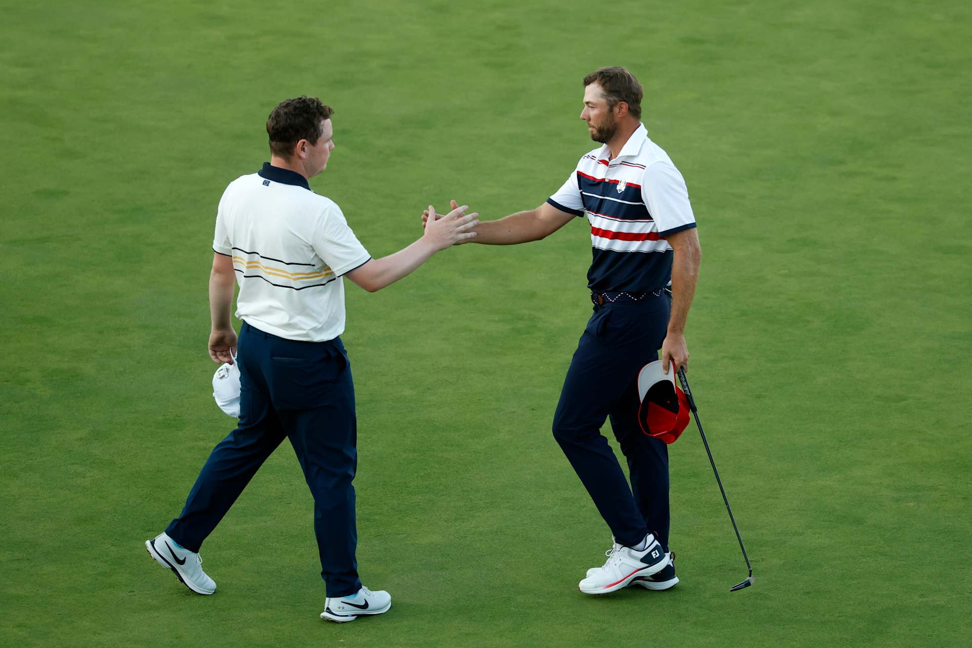 FARMINGDALE, NEW YORK - SEPTEMBER 28: (L-R) Robert MacIntyre of Team Europe and Sam Burns of Team United States shake hands after they halved their match on the 18th hole during the Sunday singles matches of the 2025 Ryder Cup at Black Course at Bethpage State Park Golf Course on September 28, 2025 in Farmingdale, New York. (Photo by Harry How/Getty Images)
